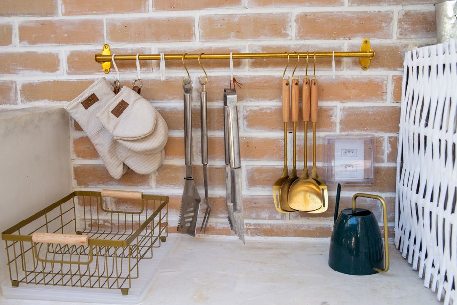 Agencement élégant de cuisine avec des ustensiles et des accessoires sur un mur en briques.
