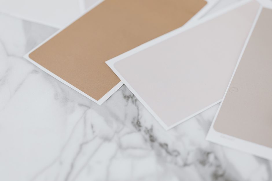 Échantillons de couleurs neutres sur une surface en marbre, idéaux pour des maquettes de design.