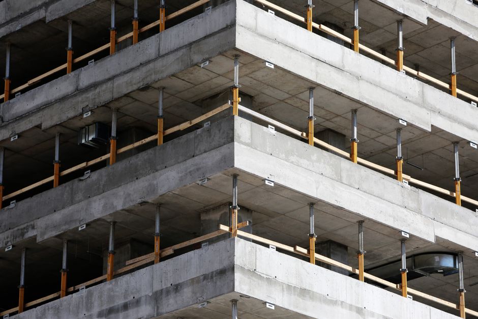 Gros plan d'un bâtiment en béton multi-niveaux inachevé avec des renforts en acier.